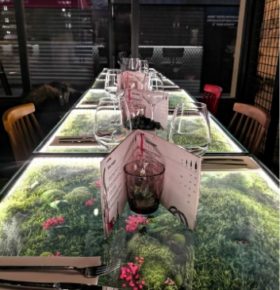 Table à manger en verre avec du végétal dans un retaurant